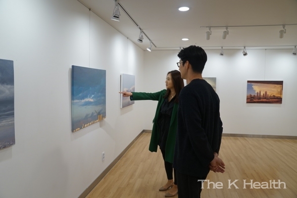 박준형 작가와 유디갤러리를 찾은 관람객이 작품에 대해 이야기를 나누는 모습(사진제공 : 유디치과)