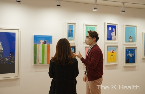 송형노 작가(오른쪽)가 유디갤러리를 방문한 관객에게 작품을 설명하는 모습(사진제공 : 유디치과)